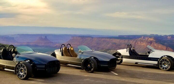 Our Vanderhall Fleet parked at a lookout point overlooking Castle Valley featuring desert towers and mesas. 